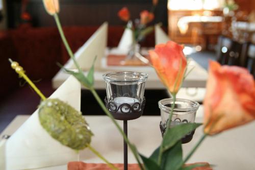 雷姆沙伊德伍珀塔尔霍夫酒店的一张桌子,上面放着两杯眼镜和鲜花