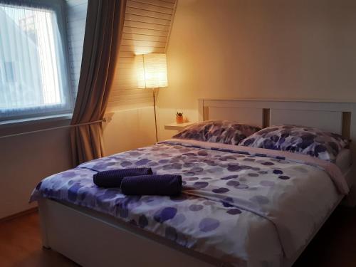 凯斯特海伊Mona apartman的一间卧室配有一张带紫色床单和灯的床