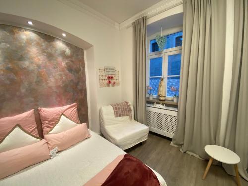 WeibernMarienzimmer的一间卧室设有一张床、一个窗口和一把椅子