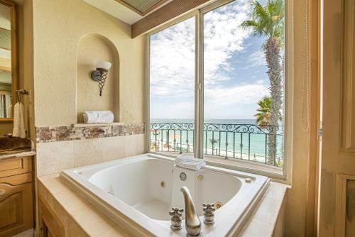 卡波圣卢卡斯Villa La Estancia - Medano Beach Villas的带浴缸的浴室和大窗户