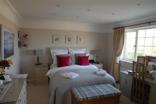 米德赫斯特Hysett House的一间卧室配有一张带红色枕头的大床