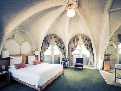 普瓦捷美居普瓦捷中心酒店的卧室设有白色大床和窗户。