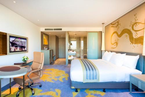 万象万象皇冠假日酒店的酒店客房设有一张大床和一张书桌。