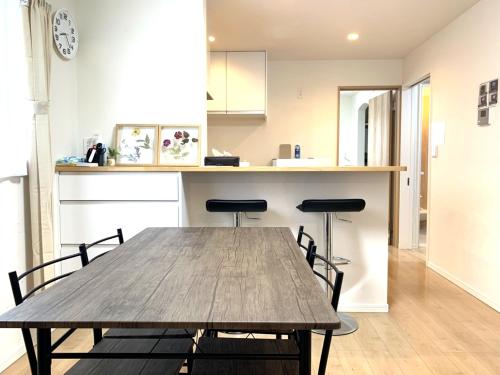 德岛Guesthouse徳島201的厨房配有木桌和两把椅子