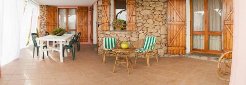 奥尔比亚Villa Bados 6 - Klodge的配有桌椅和石墙的房间