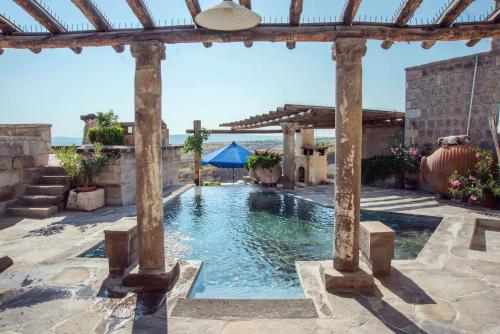 乌奇希萨尔卡帕多切城堡酒店的后院的游泳池,带凉棚