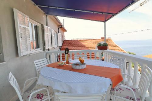 普利兹巴Apartments Villa Marijana的阳台上配有白色的桌椅