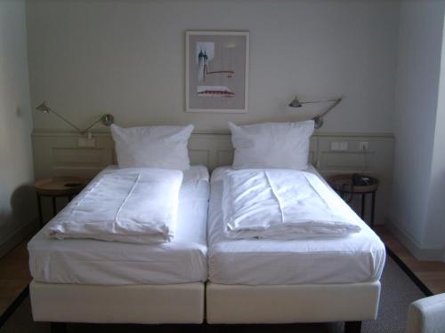 海德堡施努克罗什酒店的配有2张床的带白色床单和枕头的客房