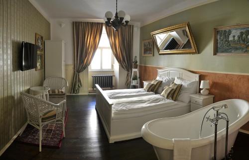 科林本森伯德威姿酒店的一间卧室配有一张床、一个浴缸和一个浴缸