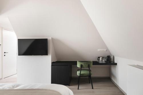 泽德尔海姆Salons Denotter的一间卧室配有一张床和一张书桌及电视