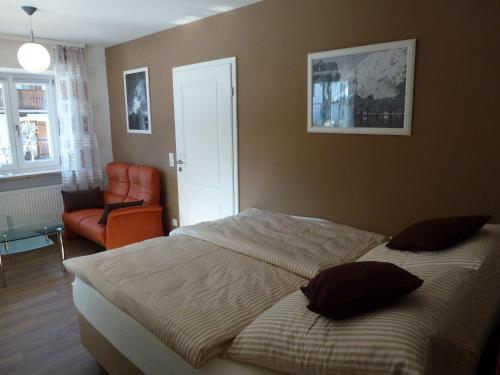 柯尼希斯湖畔舍瑙Haus Irlinger的一间卧室配有一张床和一张橙色椅子