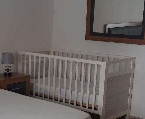拉梅特拉·德·玛尔CAL SAMARRA的卧室内的白色婴儿床,带镜子