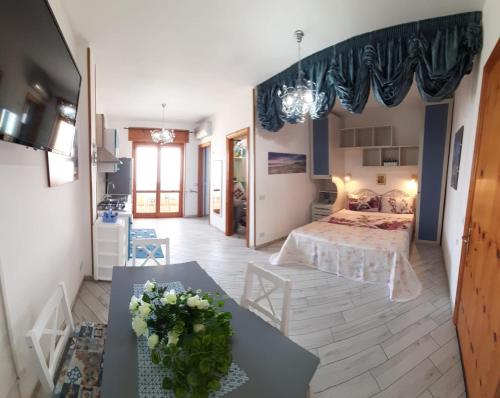奥特朗托Bilocale Punta Rosa - Fronte Spiaggia的一间房间,里面设有一张床和一张鲜花桌