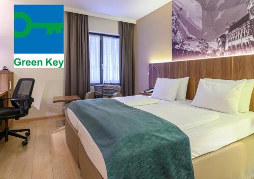 布鲁塞尔Holiday Inn Brussels Schuman, an IHG Hotel的酒店客房的墙上设有一张带绿色钥匙标志的床。