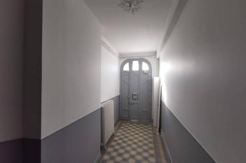 兰斯La Maison de Timothée 11 couchages的走廊上设有门,铺有瓷砖地板