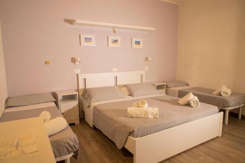 里乔内Hotel Arlecchino Riccione的一间设有两张床铺和毛巾的房间