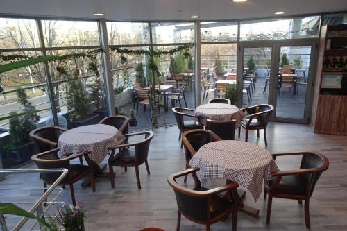 普洛耶什蒂Hotel Nord的餐厅设有桌椅和窗户。