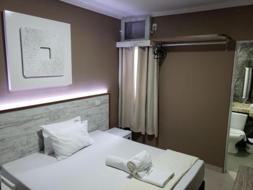 圣保罗佩尔迪吉斯之角酒店的卧室配有白色的床和镜子