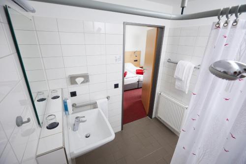 明斯特顾腾希尔滕酒店的一间带水槽和淋浴的浴室