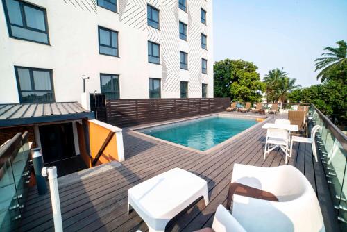 杜阿拉ONOMO Hotel Douala的一个带游泳池和大楼的甲板
