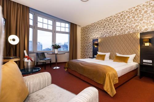 莱比锡莱比锡皇家国际酒店的酒店客房,配有床和沙发