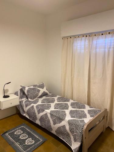Muñizcasa Muñiz的一间卧室配有一张带黑白色棉被的床