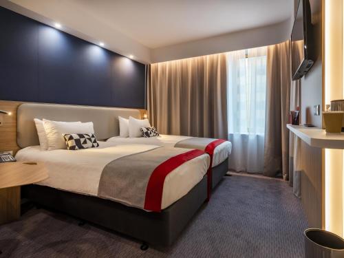 尼斯Holiday Inn Express - Nice - Grand Arenas, an IHG Hotel的酒店客房设有床和窗户。