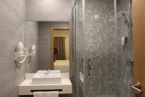 塞尔帕Hotel Beatriz的一间带水槽和玻璃淋浴的浴室