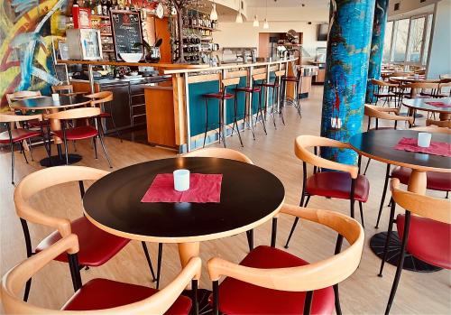 黑尔博尔茨海姆海威高速公路酒店的一间带桌椅的餐厅和一间酒吧