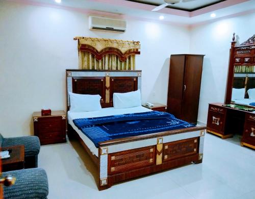 卡拉奇New Royal Residency PECHS的一间卧室配有一张大床和木制床头板