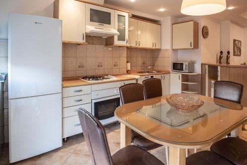 斯科普里Apartment Emilija的厨房配有桌子和白色冰箱。