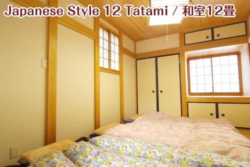 日光NIKKO stay house ARAI - Vacation STAY 14994v的一间卧室设有一张床和两个窗户。