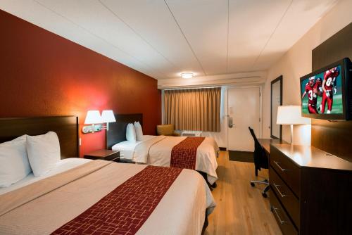 玛丽埃塔Red Roof Inn Marietta的酒店客房设有两张床和一台平面电视。