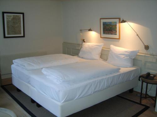 海德堡施努克罗什酒店的一张带白色床单和枕头的床