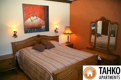 库奥皮奥普鲁德别墅的卧室配有一张床,墙上挂有绘画作品