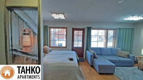塔库沃里Apartments Tahko的客厅配有沙发、蓝色沙发和窗户。