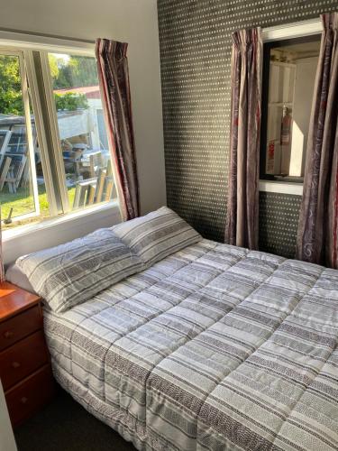 陶波Windsor Motel的卧室在窗户前配有一张床
