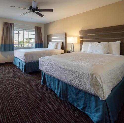 默塞德Rodeway Inn Near University-Gateway to Yosemite的酒店客房设有两张床和窗户。