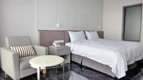 花莲市玫瑰香榭饭店的一间卧室配有一张床、一张沙发和一把椅子