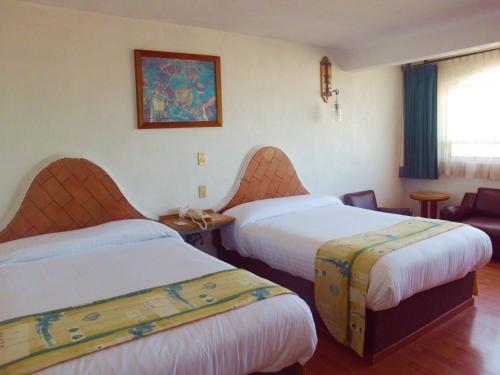 Apizaco拉波萨达酒店的酒店客房,设有两张床和一张沙发