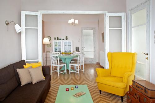 卡拉内拉Avgi by the Sea的客厅配有沙发、桌子和黄色椅子
