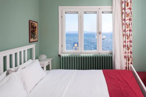 卡拉内拉Avgi by the Sea的一间卧室设有一张床和一个海景窗户