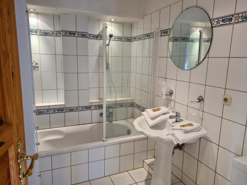 霍瓦赫特思罗斯特酒店的一间带水槽、浴缸和镜子的浴室
