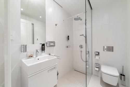 德累斯顿Modernes Apartment am Neumarkt的白色的浴室设有水槽和淋浴。