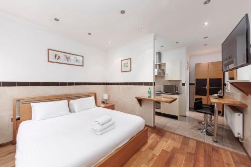 伦敦Argyle Apart Hotel的一间带白色大床的卧室和一间厨房