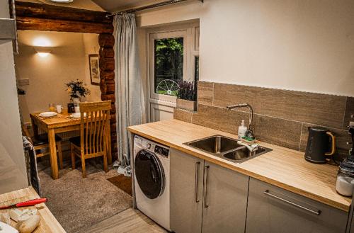 考文垂Log cabin的厨房配有水槽和洗衣机