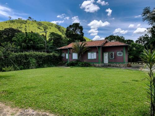 帕萨夸特鲁Pousada das Pedras的前面有绿色草坪的房子