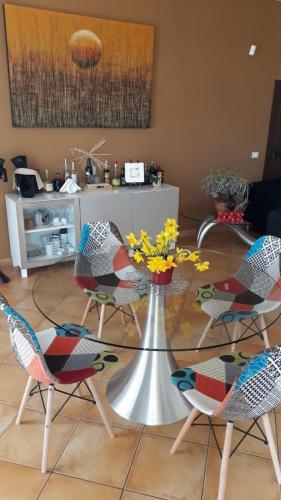 阿尔泰纳Il Faggio 17 B&B的一张带椅子的玻璃桌和一张带鲜花的桌子