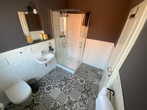 汉诺威Aparthotel Charlotten的带淋浴、卫生间和盥洗盆的浴室