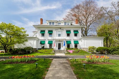 格林威治Stanton House Inn的白色的房子,有绿色百叶窗和鲜花